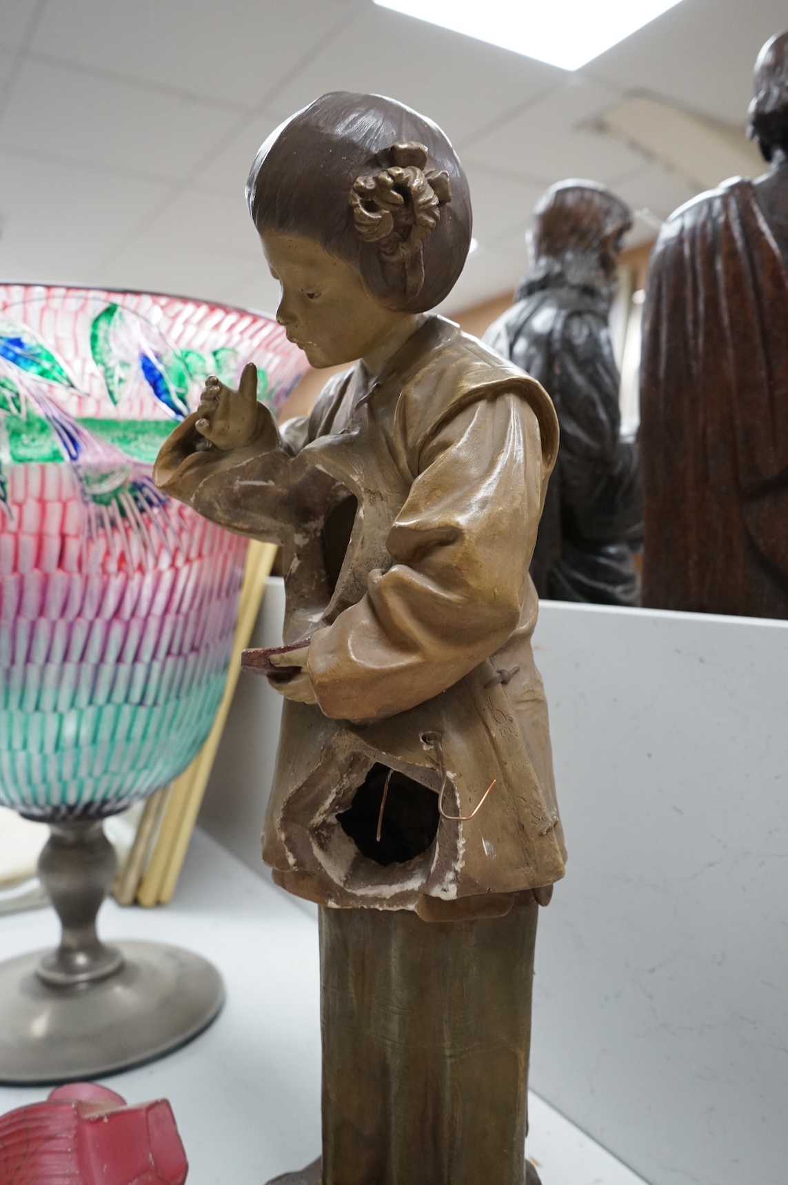 A Goldscheider cold-painted terracotta figural lamp with two cranberry glass shades, 55cm high